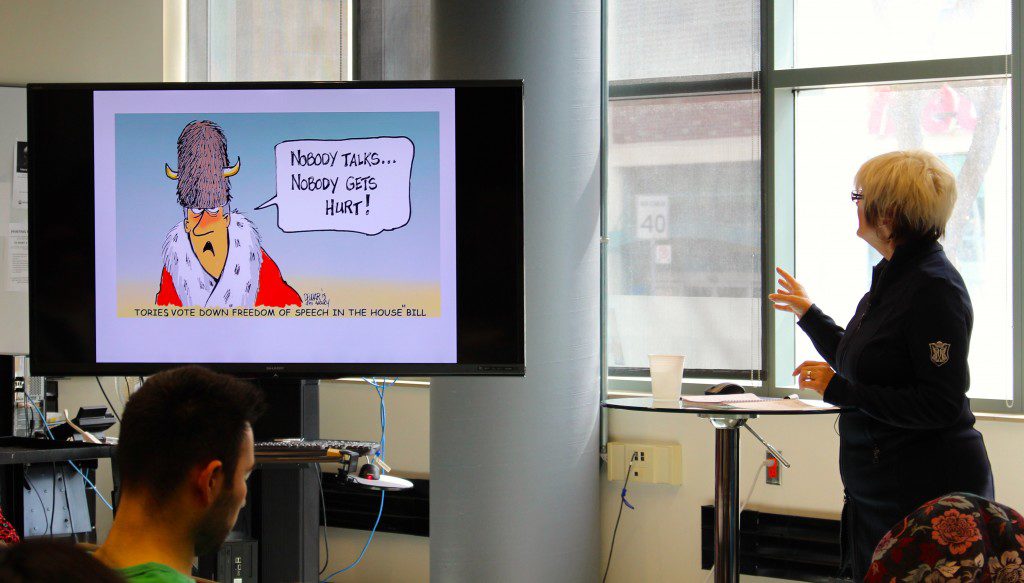 Cartoonist Susan Dewar presenting before an audience at the 2015 Atkinson Lecture. (Photo: Robert Liwanag)