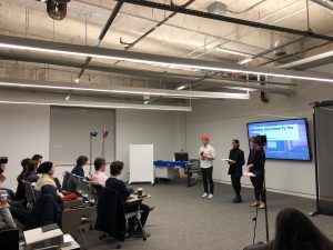 Students conduct a presentation in front of multiple students.